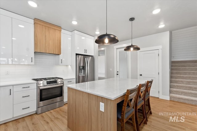 6811 W Los Flores Dr, Meridian, ID 83646 - kitchen with pendant lighting, stainless steel appliances, a kitchen island, and white cabinets