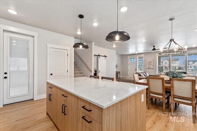 6811 W Los Flores Dr, Meridian, ID 83646 - kitchen featuring a barn door, modern cabinets, a kitchen island, and decorative light fixtures