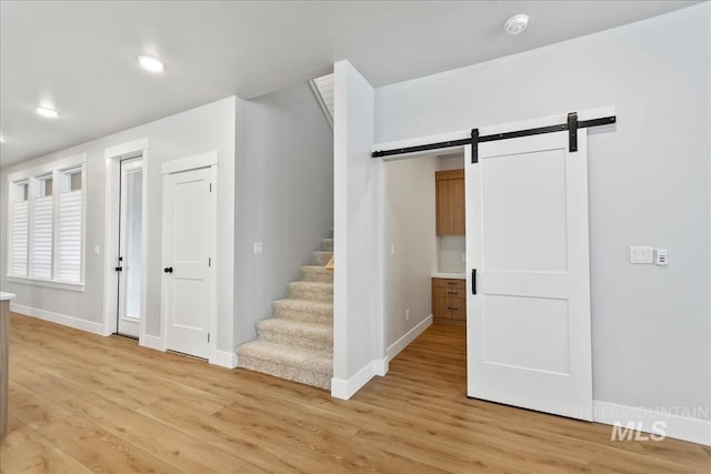 6811 W Los Flores Dr, Meridian, ID 83646 - stairway with a barn door, baseboards, and wood finished floors