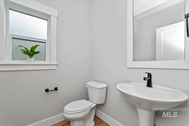6811 W Los Flores Dr, Meridian, ID 83646 - half bath featuring a sink, wood finished floors, toilet, and baseboards