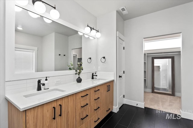 6811 W Los Flores Dr, Meridian, ID 83646 - full bathroom featuring double vanity, tasteful backsplash, a sink, and baseboards