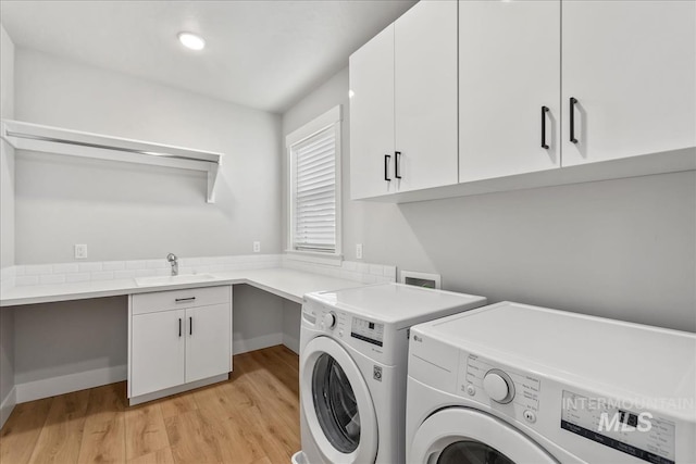 6811 W Los Flores Dr, Meridian, ID 83646 - laundry area featuring light wood-type flooring, cabinet space, a sink, and washing machine and clothes dryer