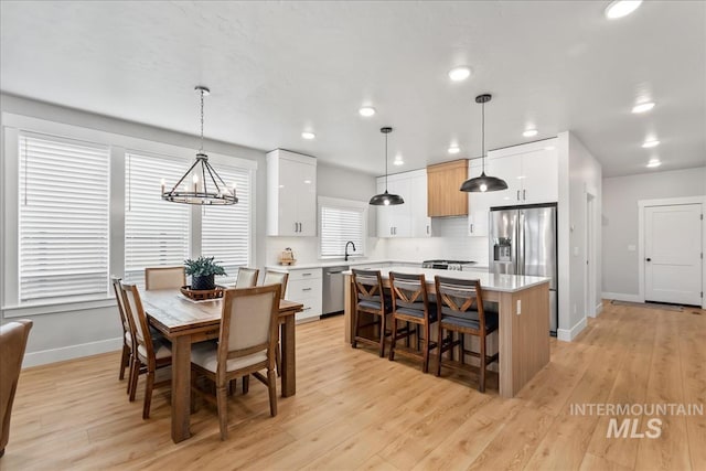 6811 W Los Flores Dr, Meridian, ID 83646 - dining space featuring baseboards, recessed lighting, a notable chandelier, and light wood-style floors