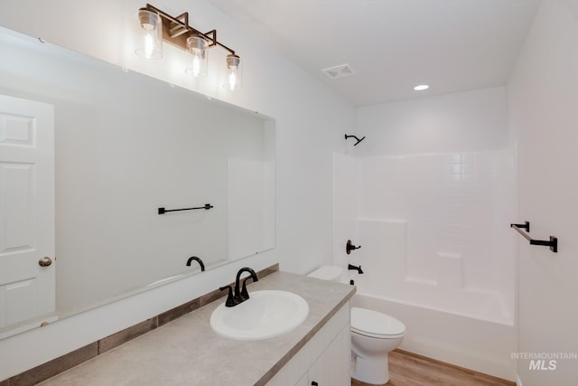 full bathroom with shower / bathing tub combination, wood-type flooring, vanity, and toilet