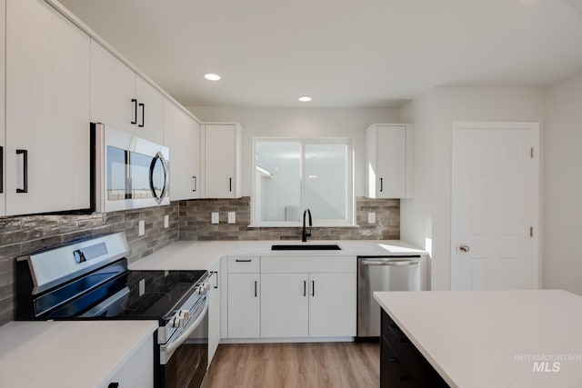 kitchen featuring white cabinets, light hardwood / wood-style floors, sink, and stainless steel appliances