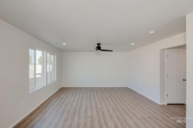 spare room with ceiling fan, light hardwood / wood-style flooring, and a textured ceiling