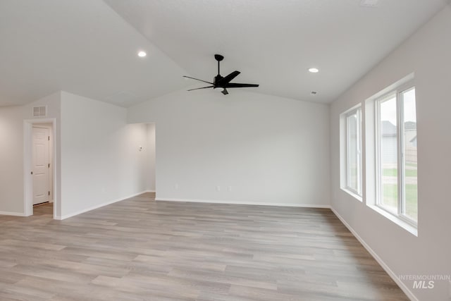 empty room featuring lofted ceiling, light wood finished floors, recessed lighting, and baseboards