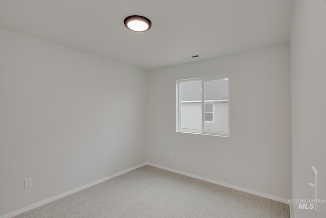 carpeted spare room with baseboards