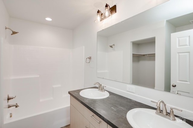 bathroom with recessed lighting, a sink, shower / bathing tub combination, and double vanity