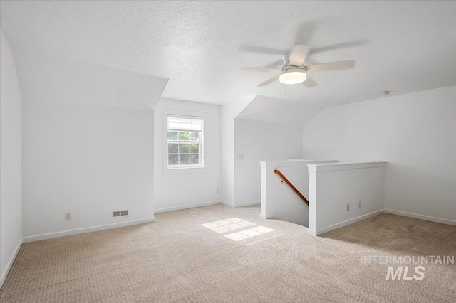 66 W Colchester Dr, Eagle, ID 83616 - bonus room featuring carpet, lofted ceiling, a ceiling fan, baseboards, and a textured ceiling