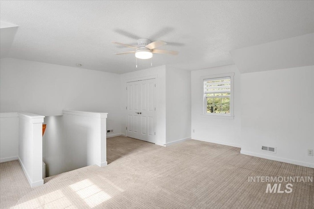 66 W Colchester Dr, Eagle, ID 83616 - carpeted spare room with baseboards, ceiling fan, a textured ceiling, and lofted ceiling