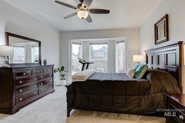 bedroom featuring light carpet, access to exterior, ceiling fan, and multiple windows