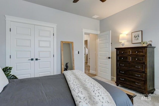 bedroom with light carpet, a ceiling fan, and a closet