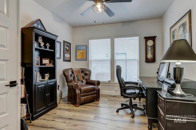 office space with light wood-style floors, ceiling fan, and baseboards