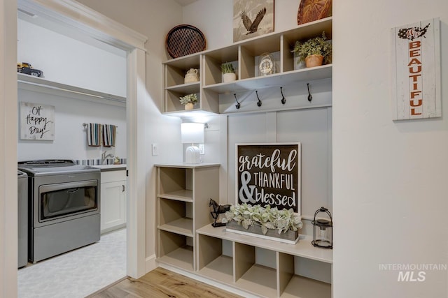 mudroom with light wood finished floors and a sink