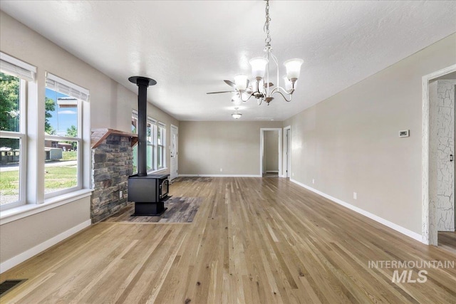 180 E Elmore, Richfield, ID 83349 - unfurnished living room with a wood stove, wood finished floors, and a chandelier