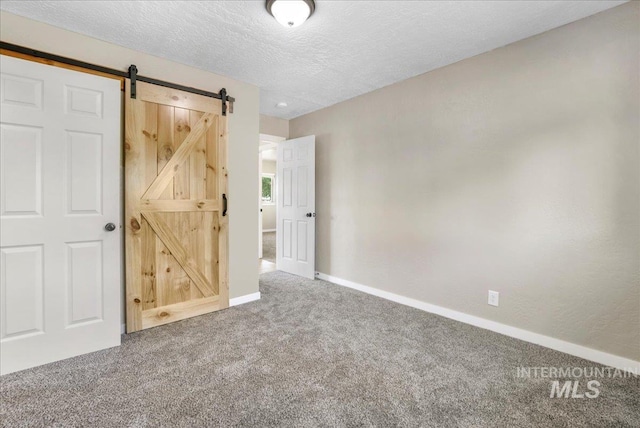 180 E Elmore, Richfield, ID 83349 - unfurnished bedroom with carpet, a barn door, and a textured ceiling