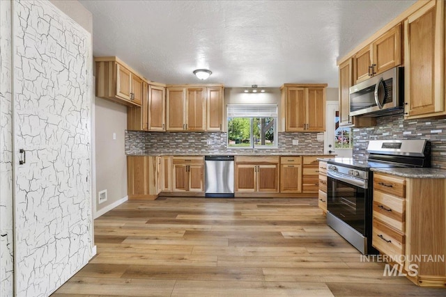 180 E Elmore, Richfield, ID 83349 - kitchen featuring stainless steel appliances, light wood finished floors, backsplash, and a textured ceiling