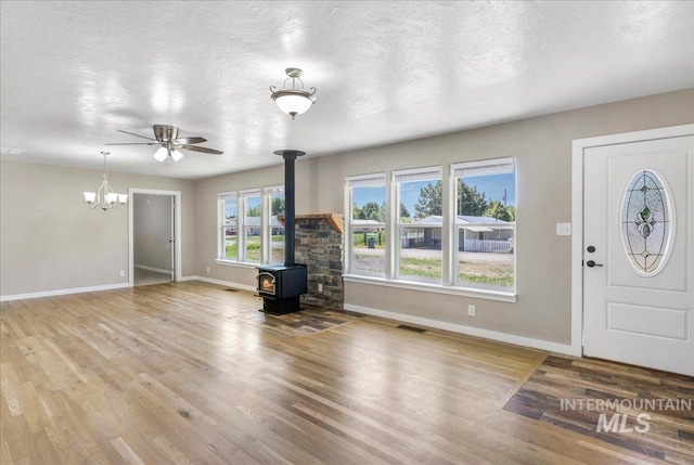 180 E Elmore, Richfield, ID 83349 - foyer entrance featuring a wood stove, wood finished floors, a chandelier, a ceiling fan, and a textured ceiling