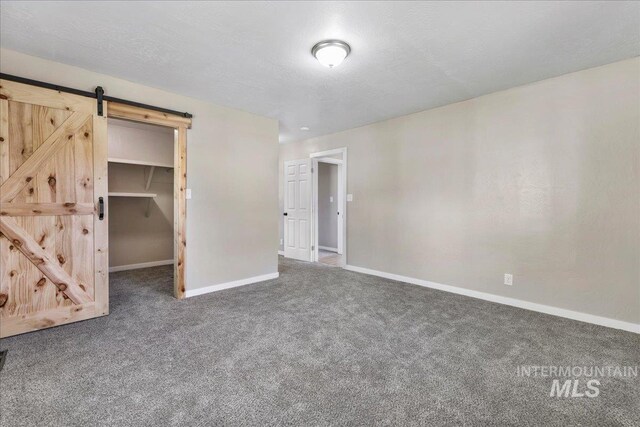 180 E Elmore, Richfield, ID 83349 - unfurnished bedroom with a barn door, carpet, and a spacious closet
