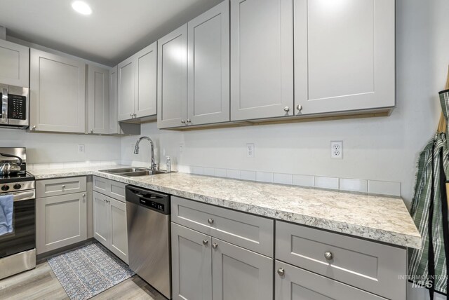 247 Washington St, Gooding, ID 83330 - kitchen featuring appliances with stainless steel finishes, a sink, gray cabinets, and light countertops