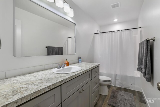 247 Washington St, Gooding, ID 83330 - bathroom featuring wood finished floors, toilet, vanity, and shower / bath combo with shower curtain