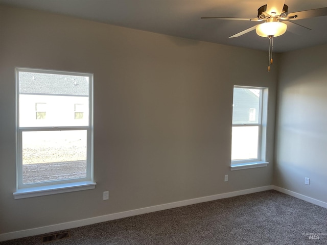 carpeted empty room with a ceiling fan, visible vents, and baseboards