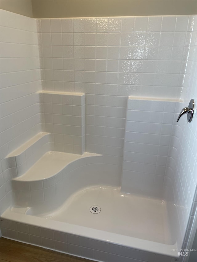 bathroom featuring wood finished floors and walk in shower