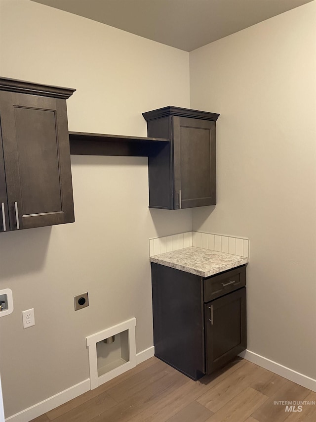 laundry room featuring cabinet space, light wood-style flooring, baseboards, and electric dryer hookup