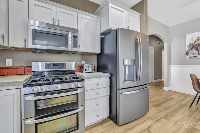 kitchen featuring light wood finished floors, white cabinetry, appliances with stainless steel finishes, and light countertops