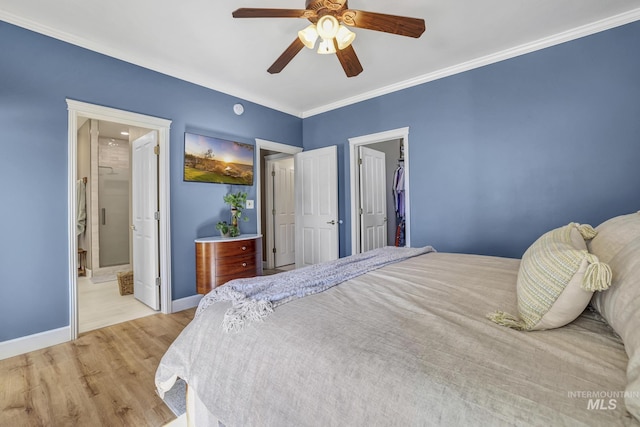 bedroom featuring crown molding, a ceiling fan, ensuite bath, wood finished floors, and baseboards