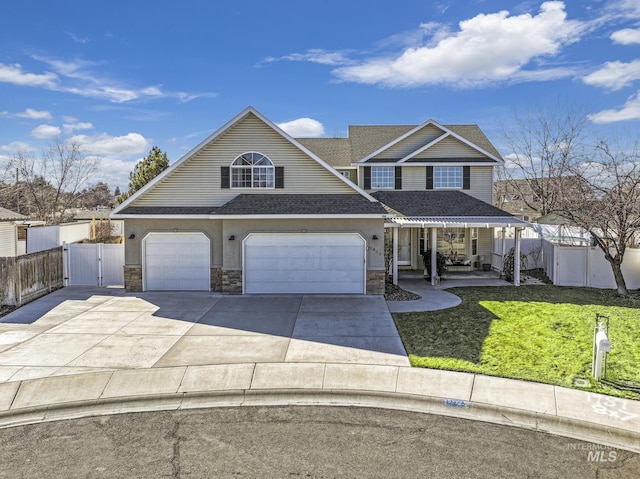 view of front of home featuring a garage, fence, stone siding, a gate, and a front lawn