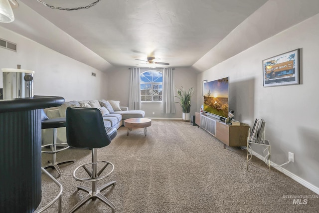 living area with vaulted ceiling, carpet flooring, visible vents, and baseboards