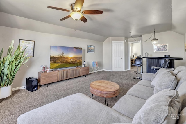 carpeted living room featuring lofted ceiling, a bar, a ceiling fan, and baseboards