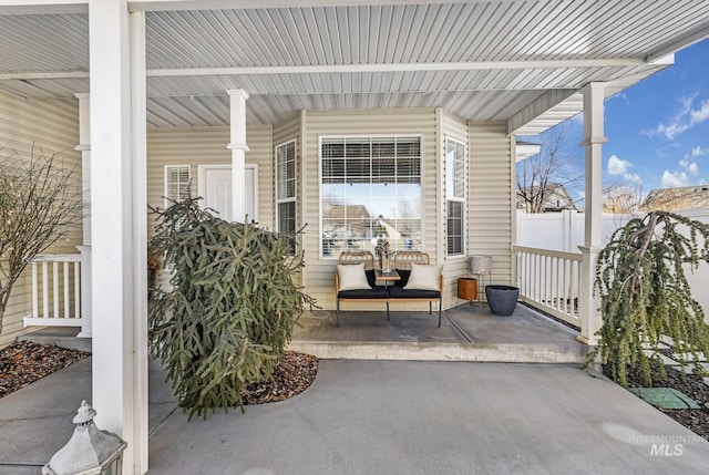 view of patio with fence and a porch