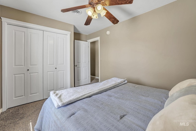 carpeted bedroom featuring a closet, visible vents, and a ceiling fan