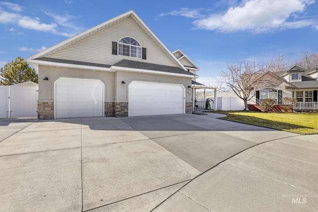 view of home's exterior with driveway, a lawn, stone siding, a gate, and fence