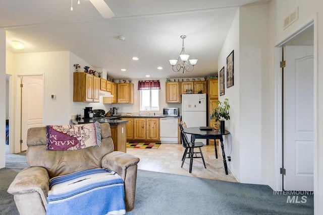 11755 E Cleft Rd, Mountain Home, ID 83647 - kitchen with white appliances, a chandelier, under cabinet range hood, recessed lighting, and dark countertops