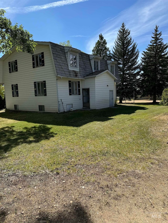 rear view of house featuring a yard