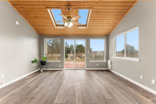 unfurnished room featuring wood finished floors, baseboards, and a wealth of natural light