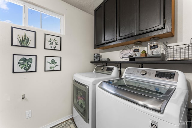 washroom featuring cabinet space, a textured ceiling, independent washer and dryer, and baseboards