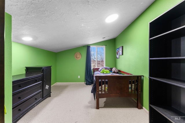 carpeted bedroom with baseboards, a textured ceiling, and lofted ceiling