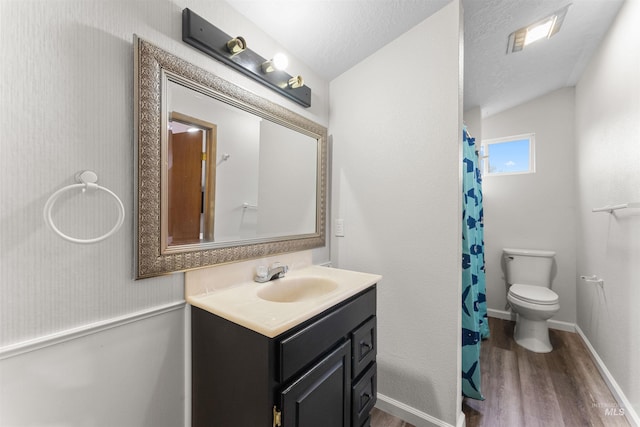 bathroom with toilet, a textured ceiling, wood finished floors, baseboards, and vanity