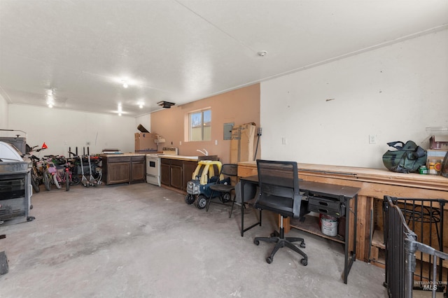 office space with electric panel, a workshop area, and unfinished concrete floors