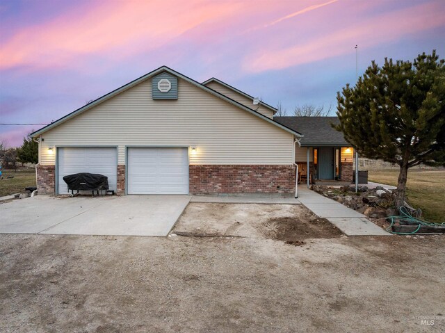 traditional-style house with a garage, brick siding, and driveway