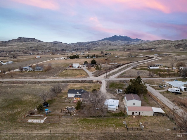 aerial view at dusk with a mountain view and a rural view