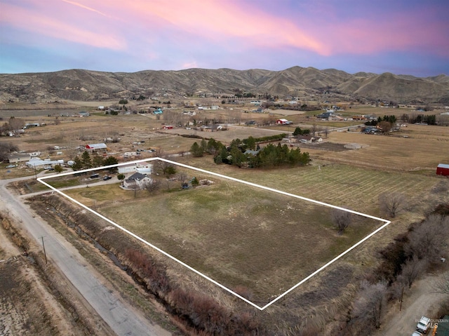 aerial view at dusk with a mountain view and a rural view