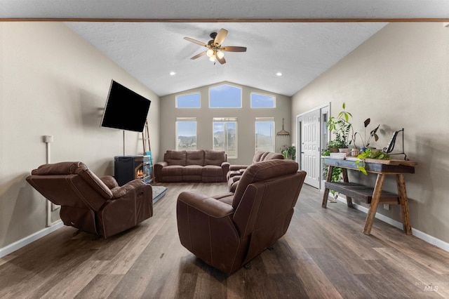 living area featuring baseboards, lofted ceiling, a textured ceiling, and wood finished floors