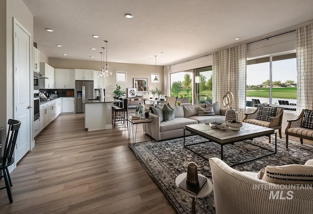 11801 W Reining Horse Ln, Kuna, ID 83634 - living area featuring recessed lighting, healthy amount of natural light, light wood-style flooring, and a chandelier