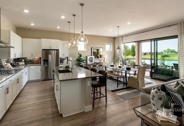 11801 W Reining Horse Ln, Kuna, ID 83634 - kitchen with appliances with stainless steel finishes, a sink, dark wood-style floors, recessed lighting, and a kitchen island with sink